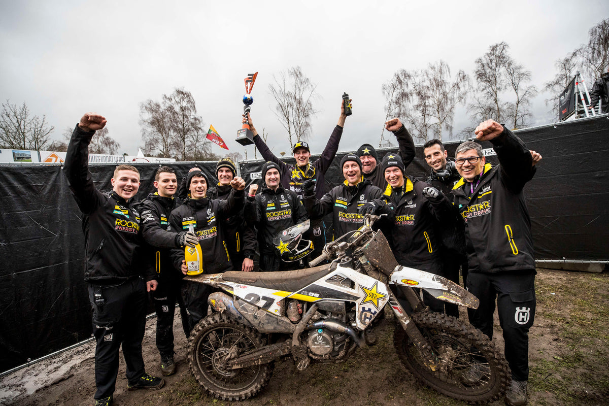A motocross team celebrating beside a bike in the Netherlands